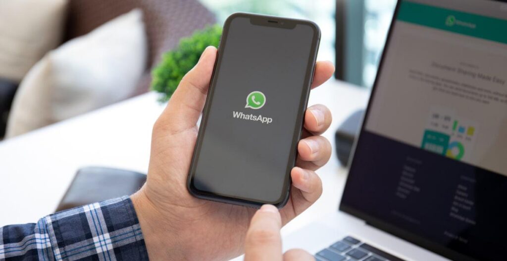 Empresário enviando mensagem profissional para cliente pelo WhatsApp utilizando estratégia de atendimento e automação.